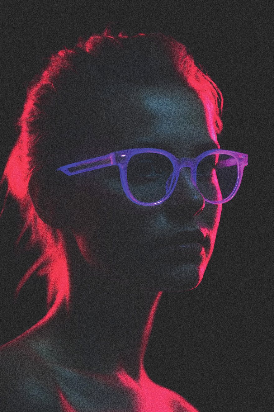 Retrato con luz magenta y gafas violeta.